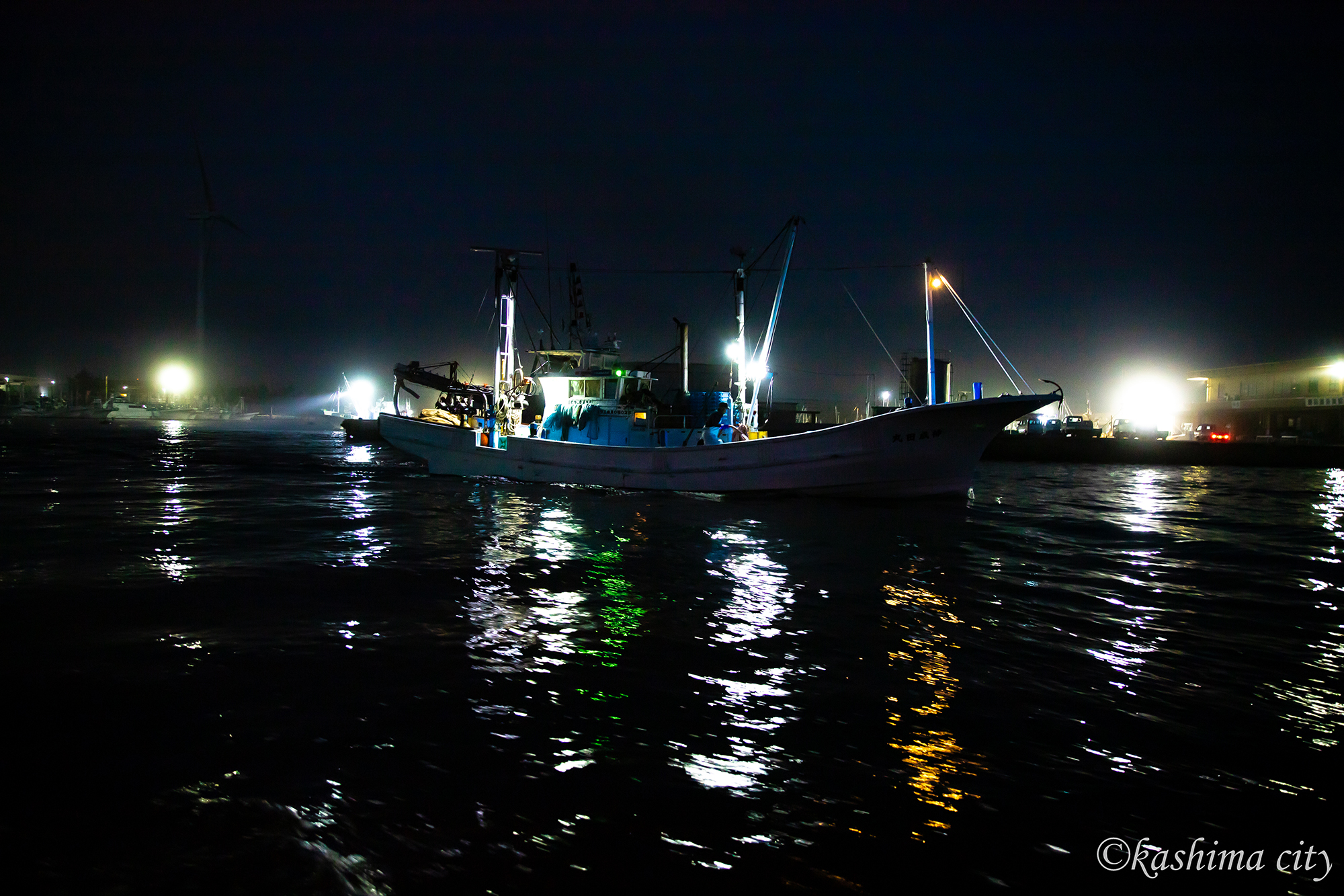 真っ暗な漁港を出発する漁船
