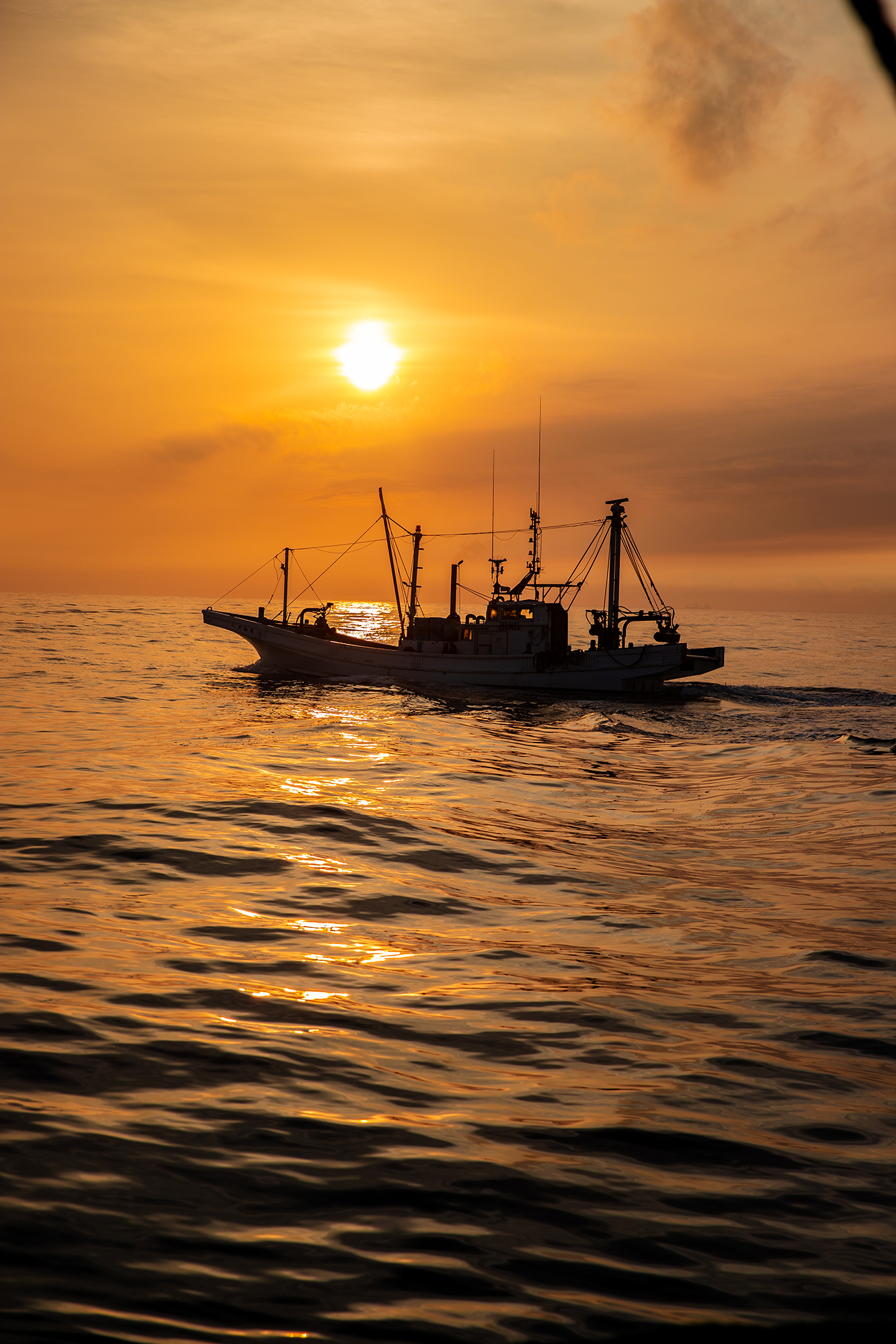 夜明けに浮かぶ漁船