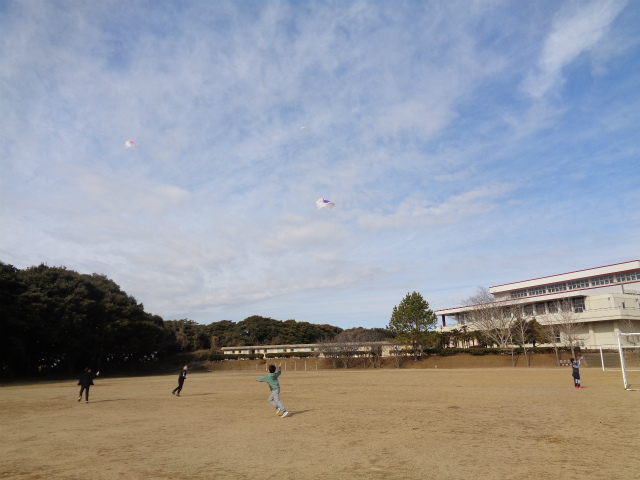 校庭で凧を飛ばす子どもたち