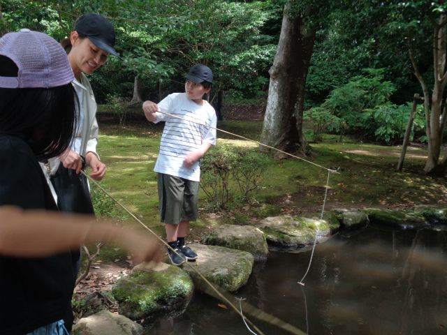 池に釣り糸を垂らす少年