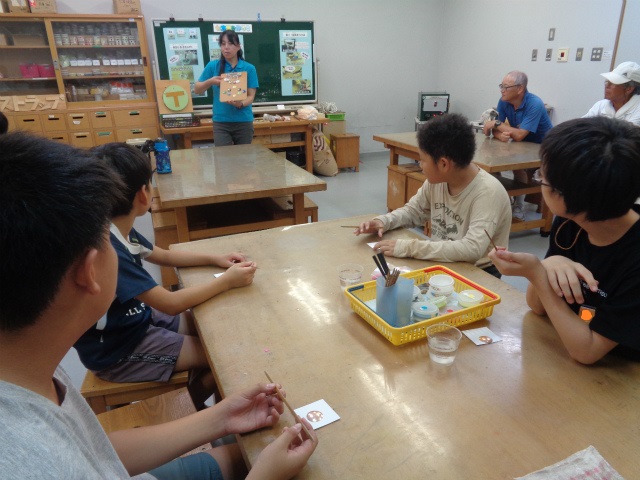 七宝焼きの説明を聞く子どもたち