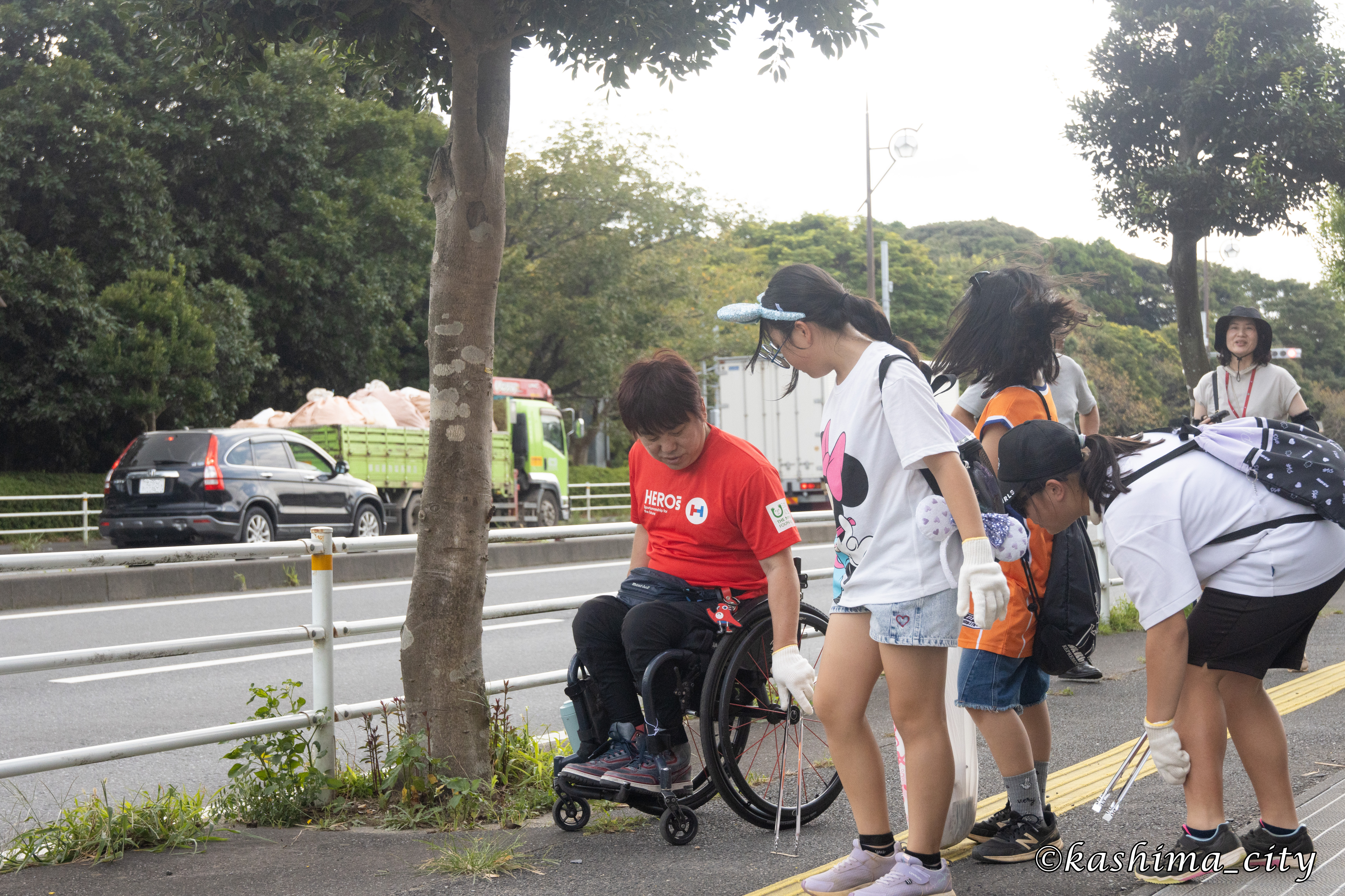 ごみを拾う根木さんと子どもたち