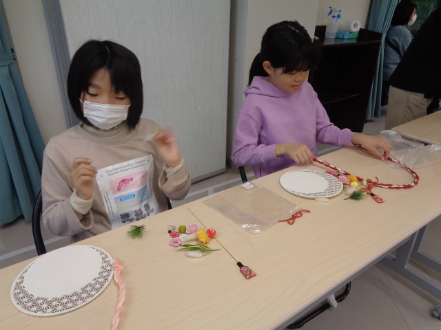 お正月飾りの部品をチェックする子ども