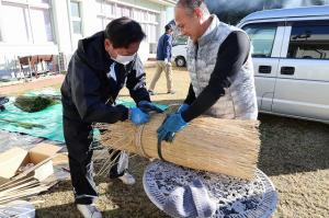 缶のまわりにわらを巻いていく