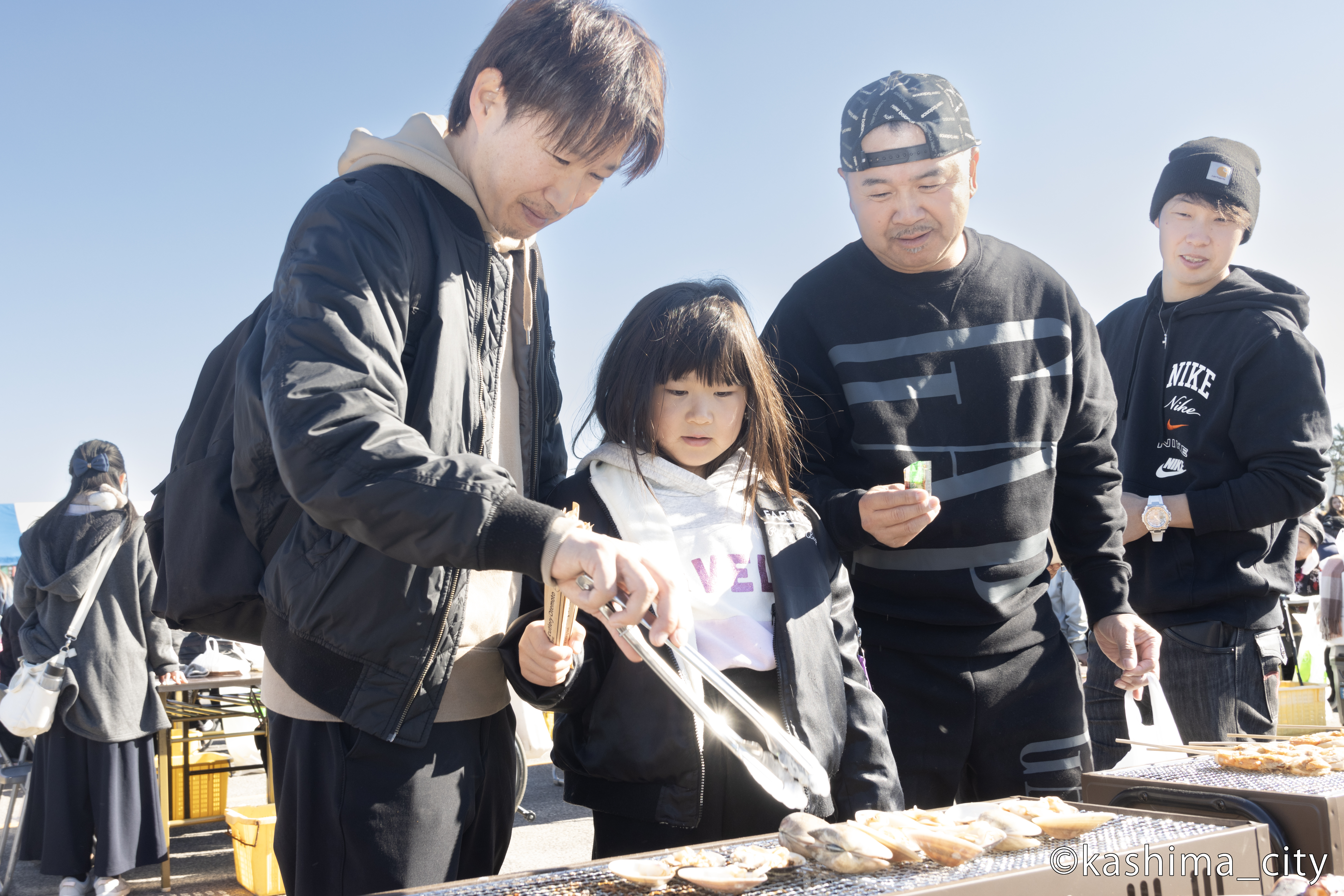 家族ではまぐりを焼く様子