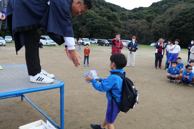 お楽しみ抽選会で賞品を渡している様子