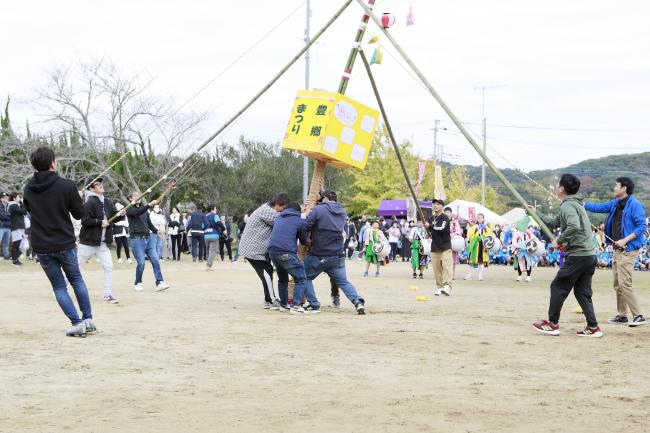 提灯祭りの竹を支える保護者