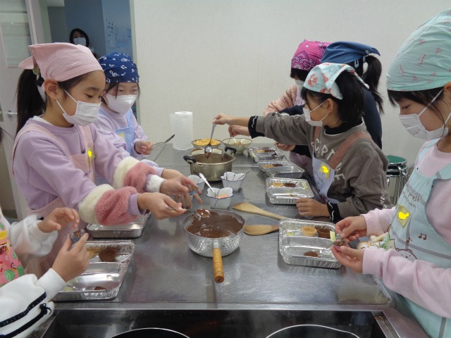 チョコを型に流す子どもたち