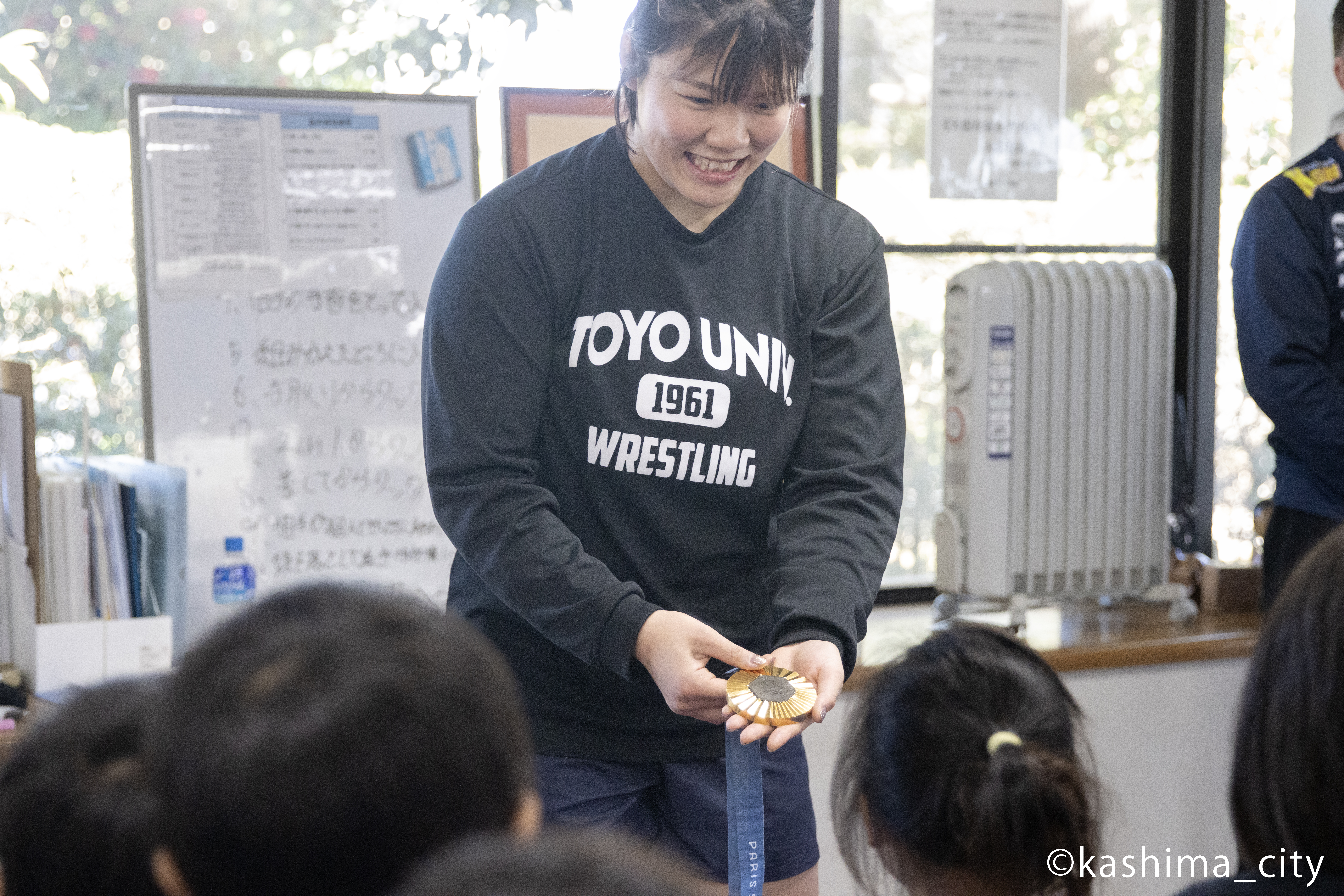 金メダルを子どもたちに見せる鏡選手