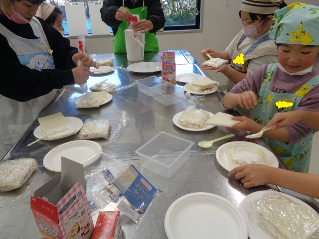 食パンにクリームを塗る子どもたち