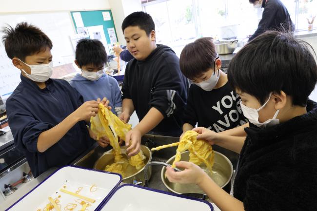 縛ったゴムや割りばしを布からほどくお手伝い