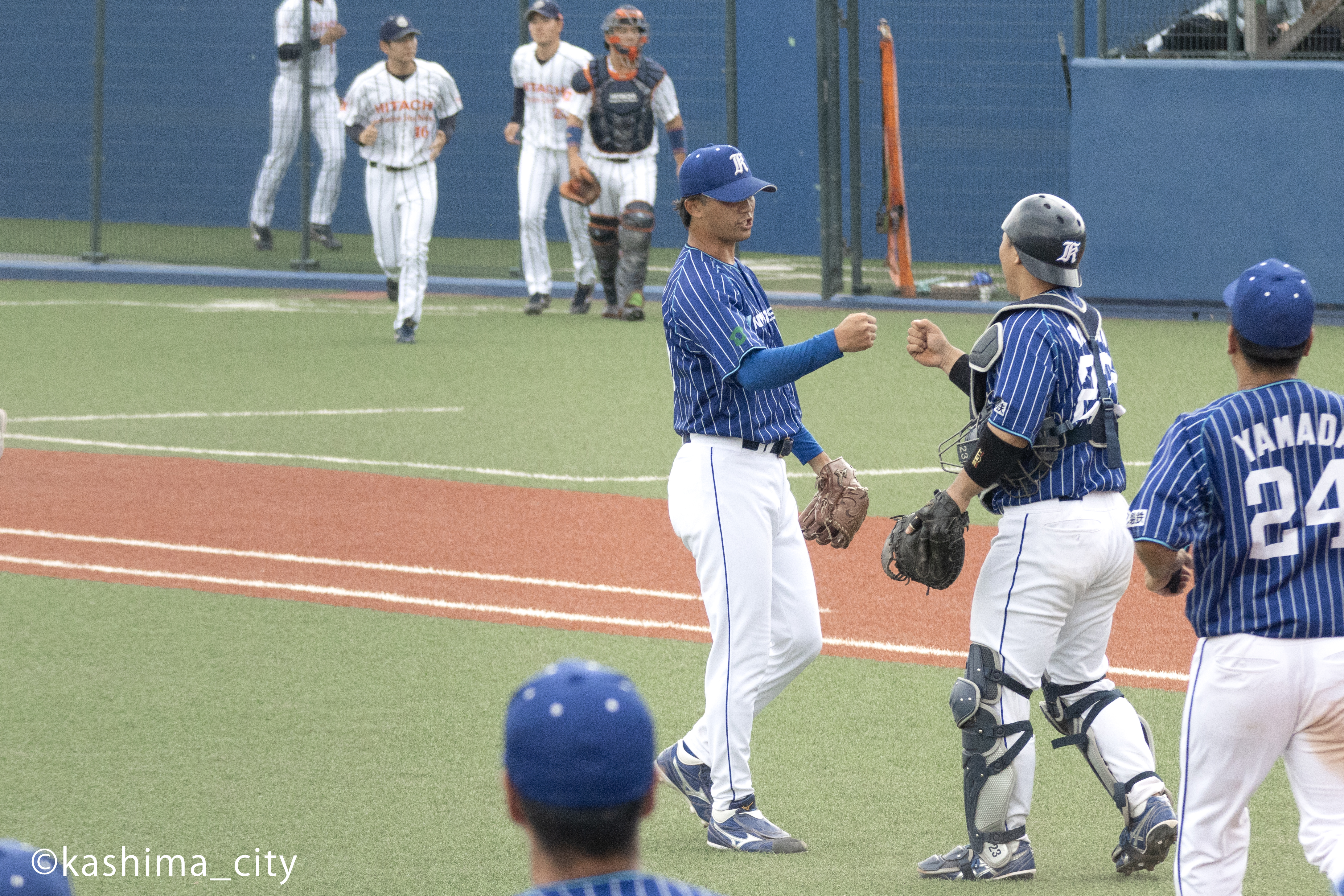 勝利して拳を合わせる金城投手と松田選手