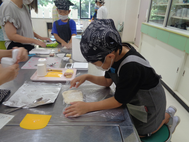 パン生地をどのように成形するか考える子ども