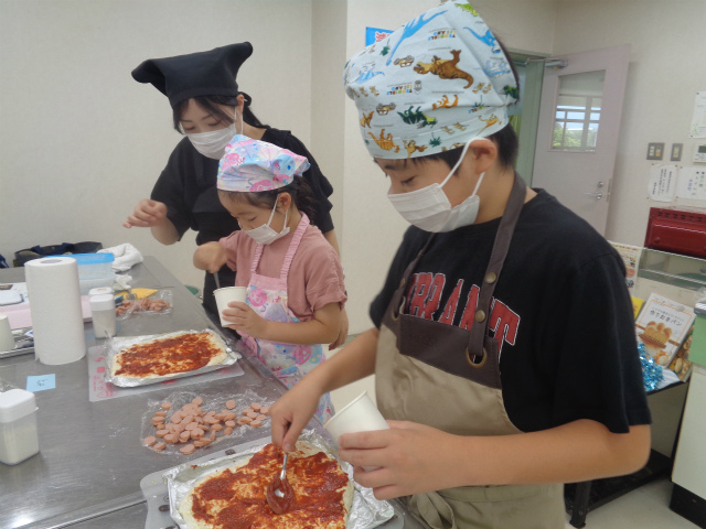 ピザソースを塗る子どもたち