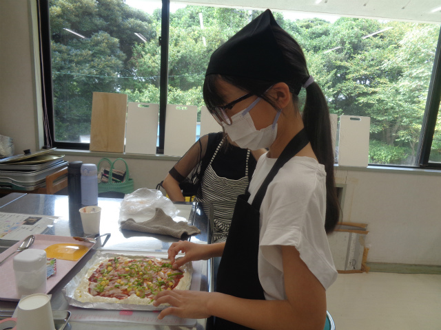 ピザに具材を載せる子ども