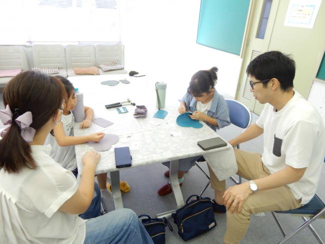 アコーディオンポーチにボタンを仮留めする作業をしています。