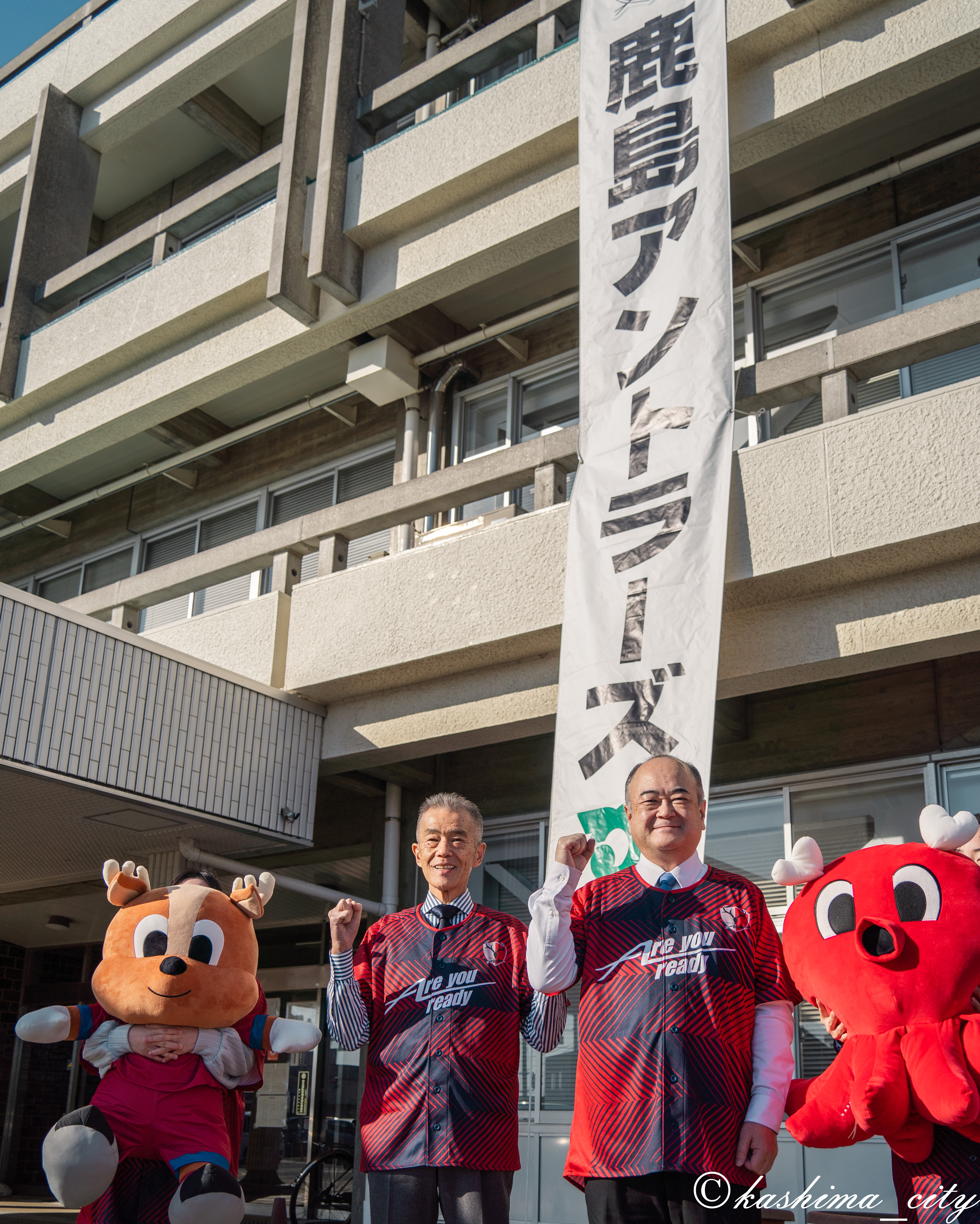 アントラーズ優勝の懸垂幕の前に立つ市長と副市長