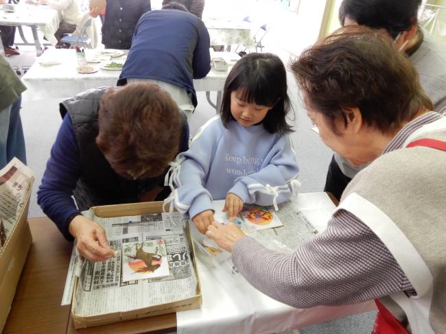 子どもと大人が集まってラメの色を選んでいる様子