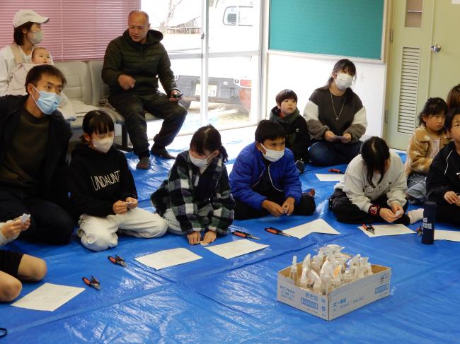 説明を聞きながら紙垂を作っていいる様子