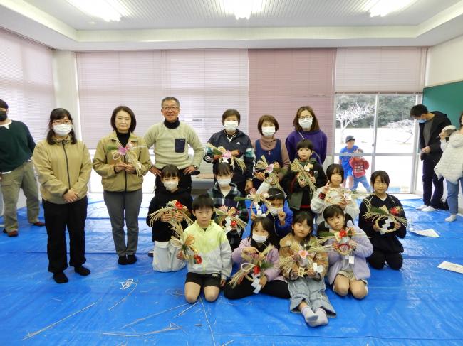 完成したリースを持った参加者と先生方の集合写真