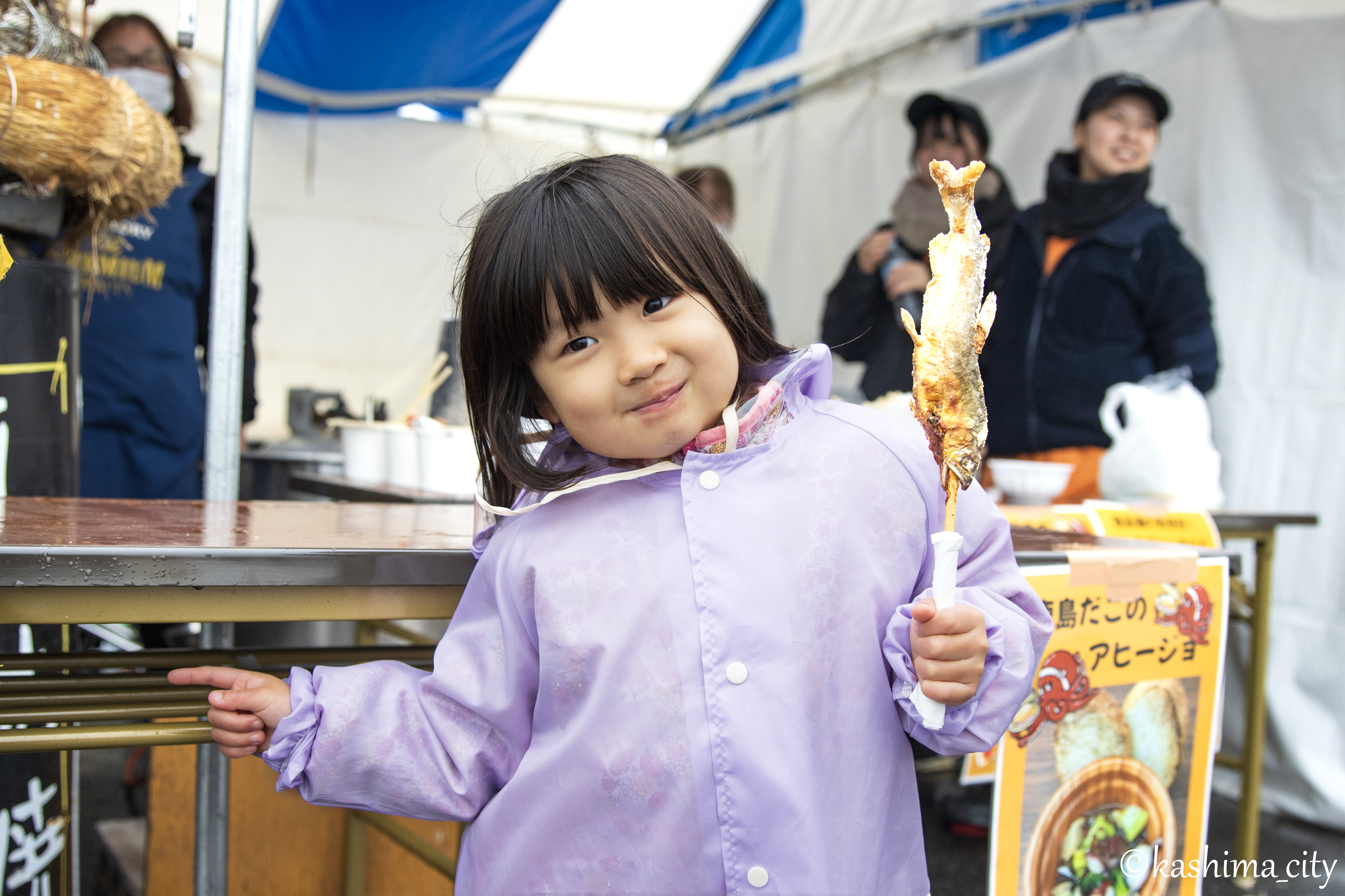 鮎の塩焼きを手に持った女の子