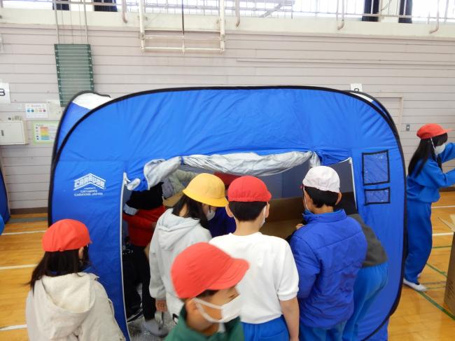 防災テントを組み立てている児童の写真