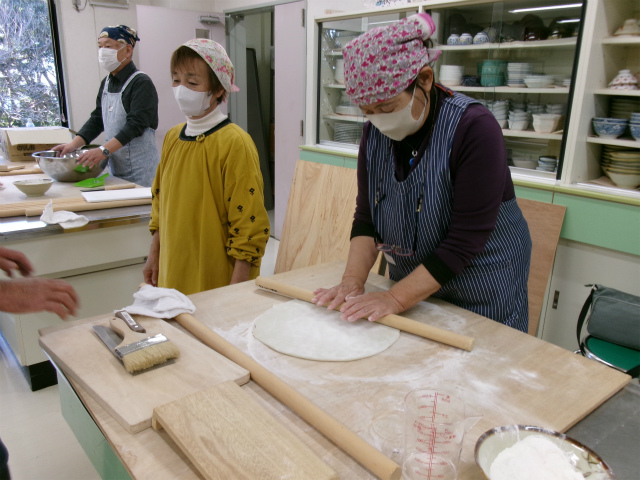 麺棒でそば粉を伸ばす参加者