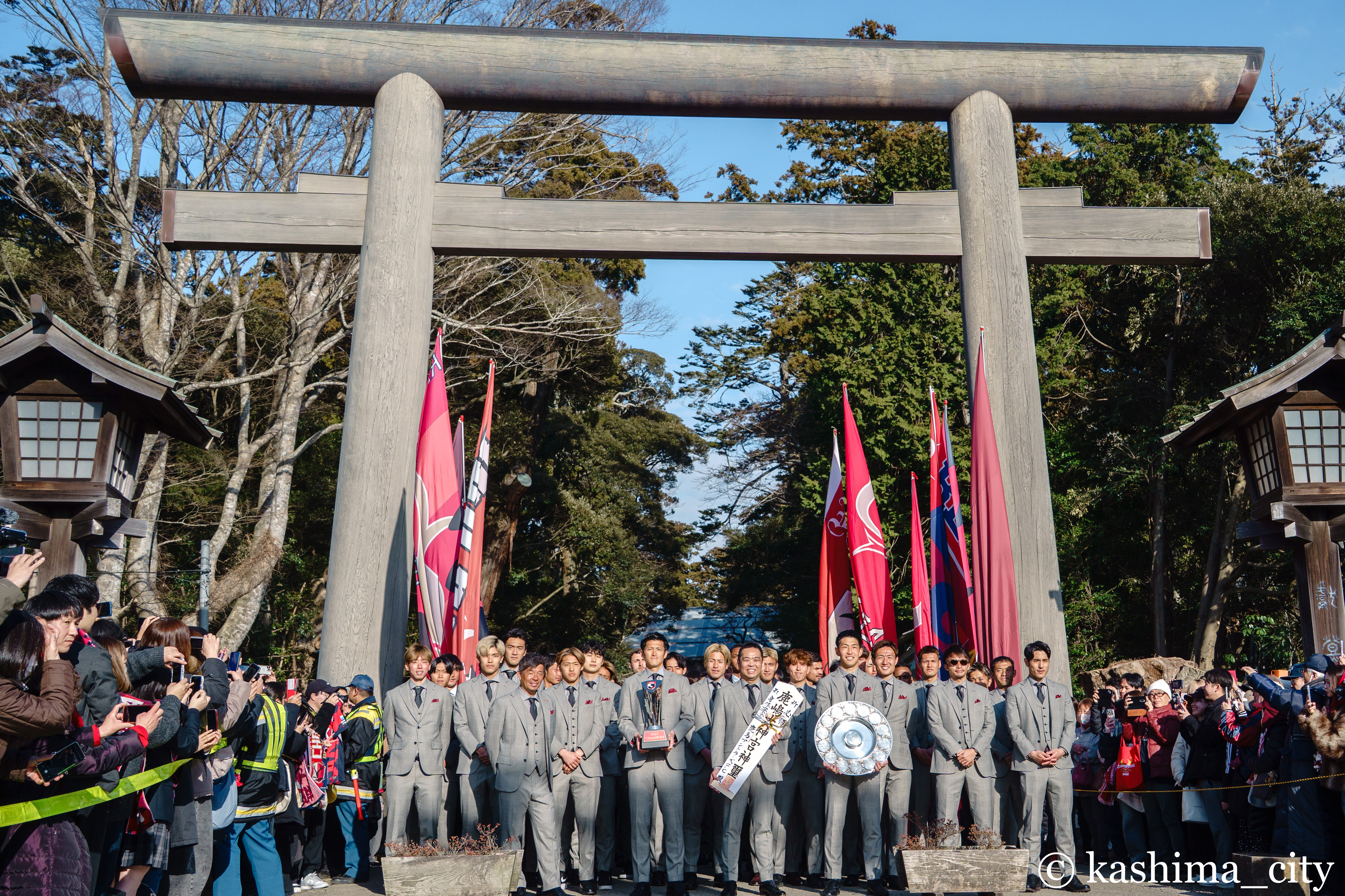 大鳥居前で集合写真を撮る選手たち