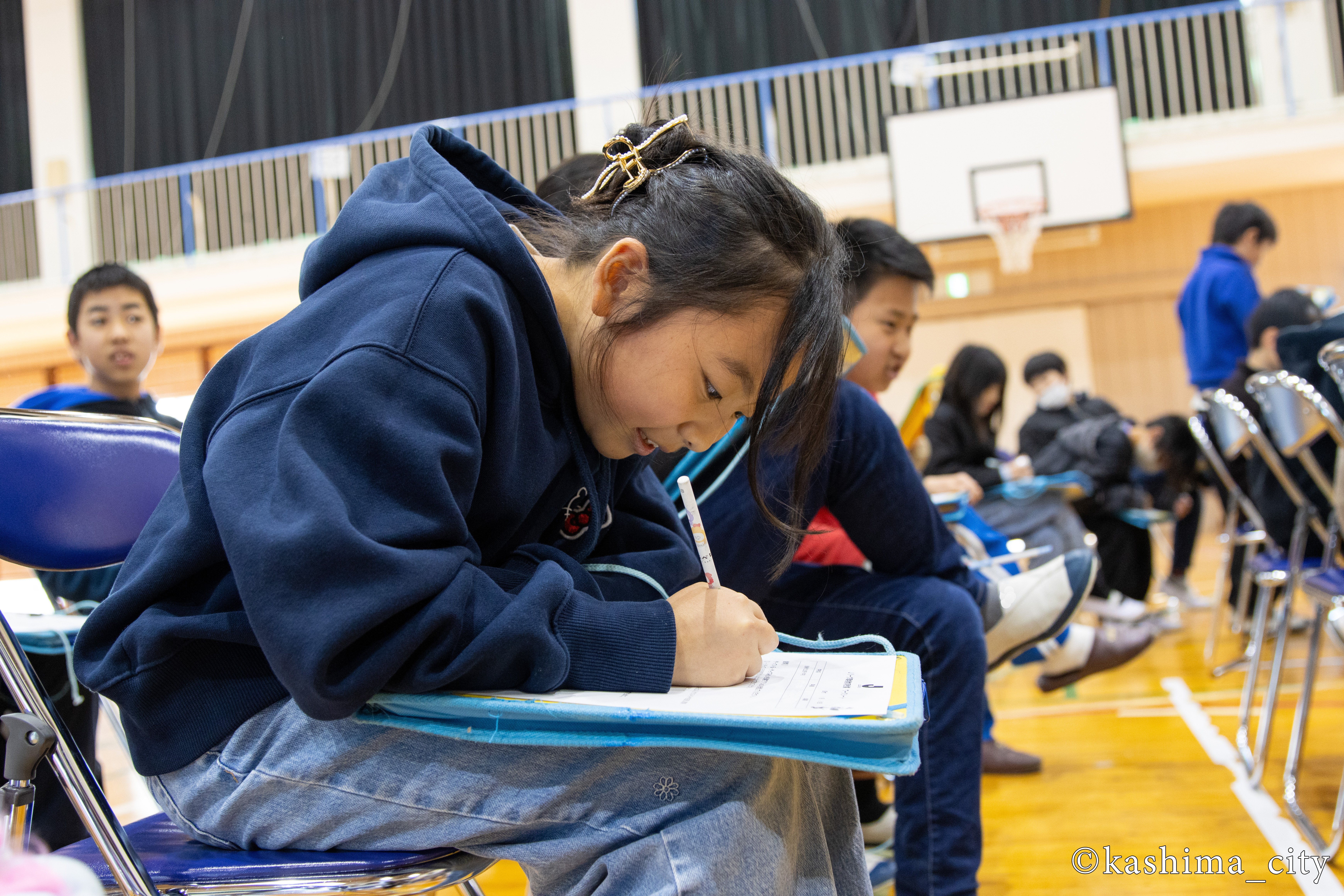 環境教育授業のワークシートに書き込む女子児童