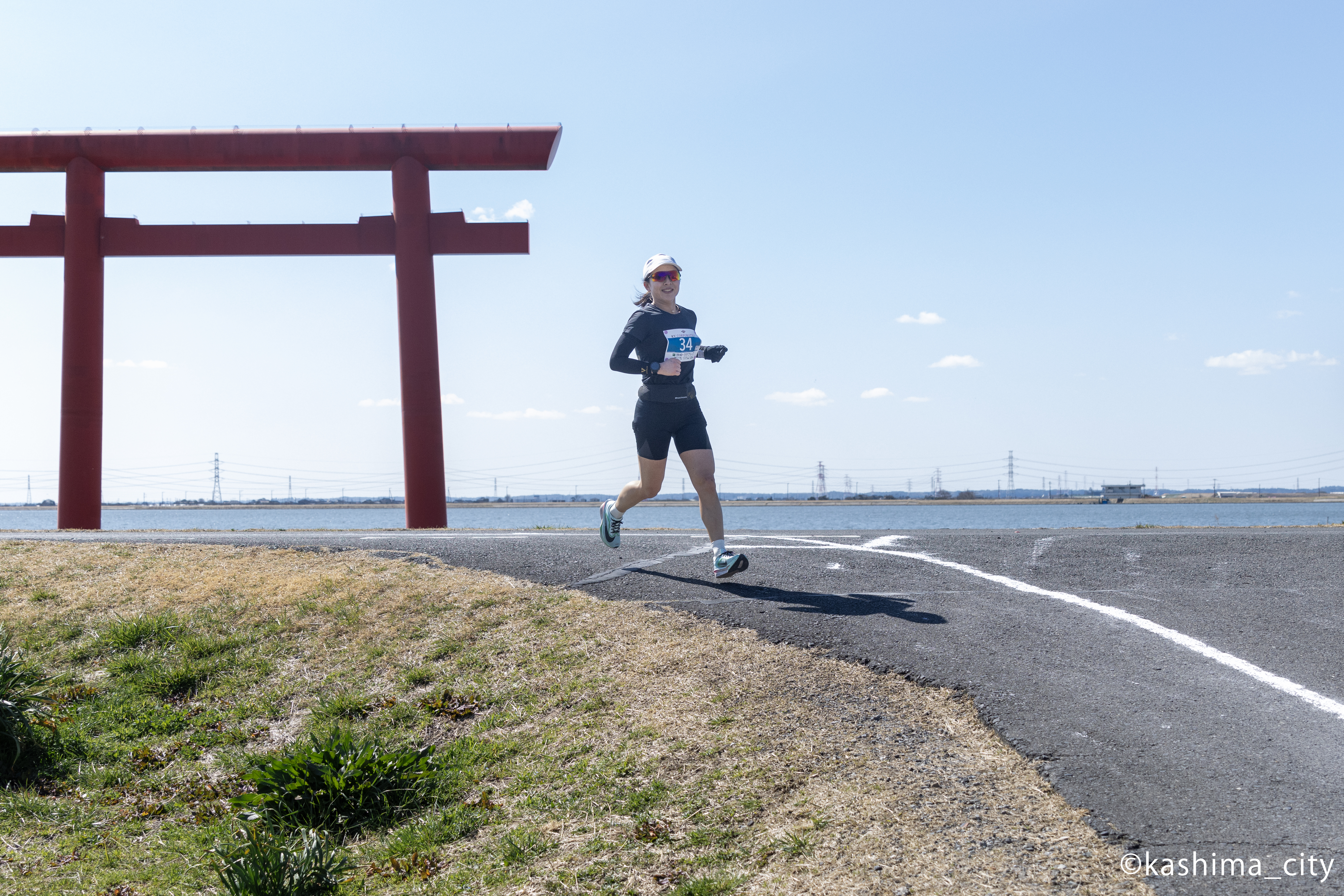 鳥居を背に走る女性