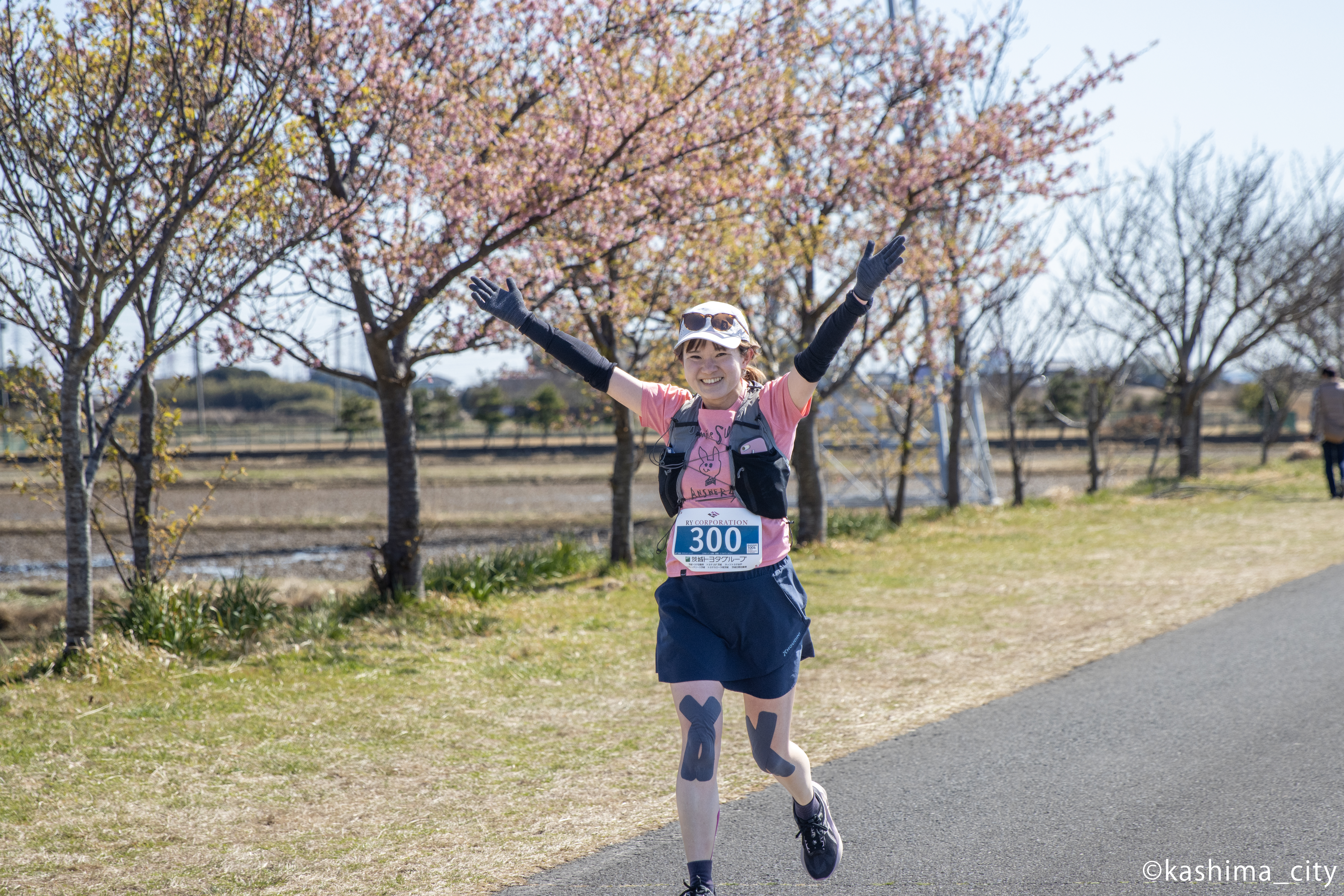 河津桜の前を走る女性