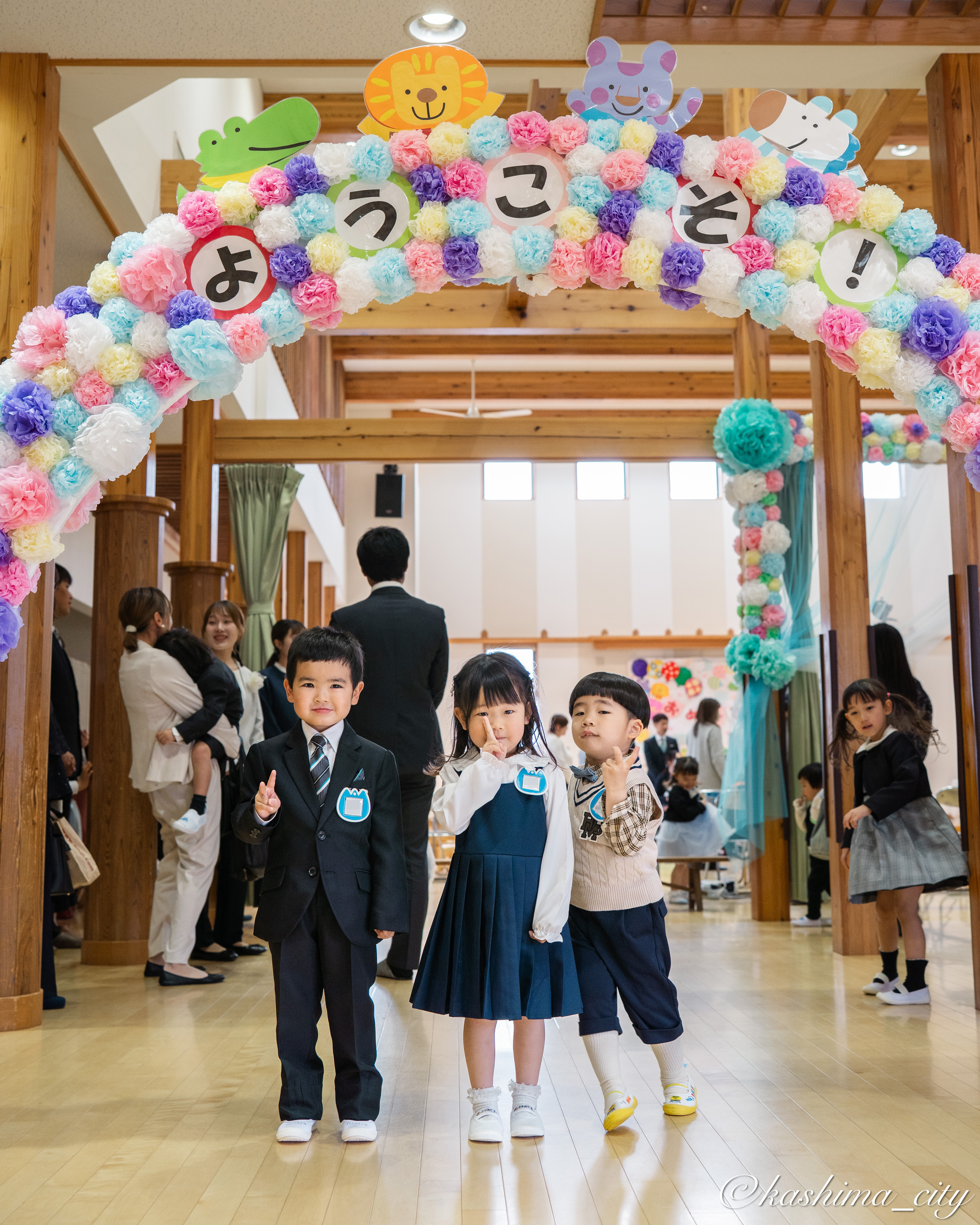 ようこそのアーチの下で笑顔の園児たち