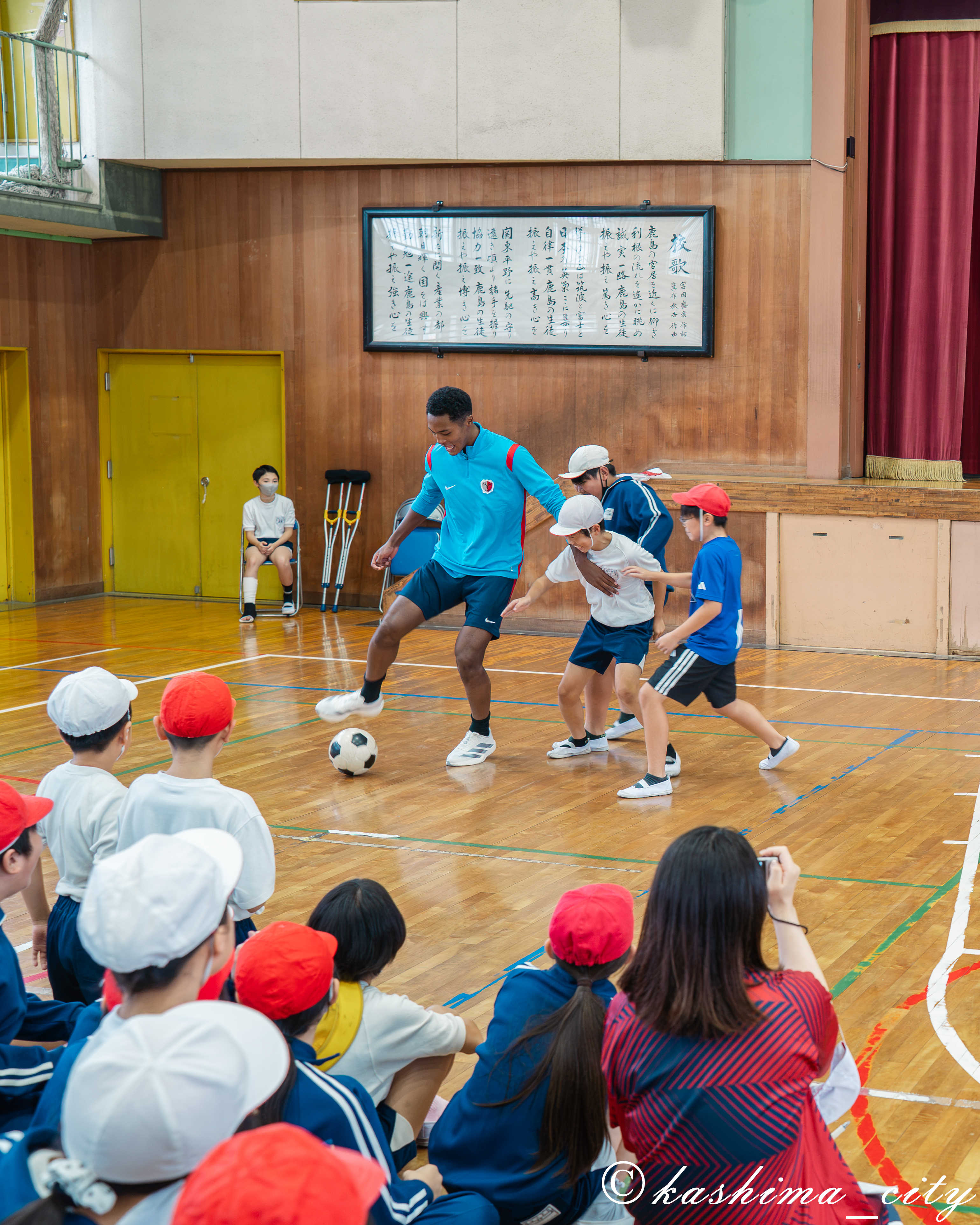 児童たちとサッカーの鳥かごを行うウデンバ選手