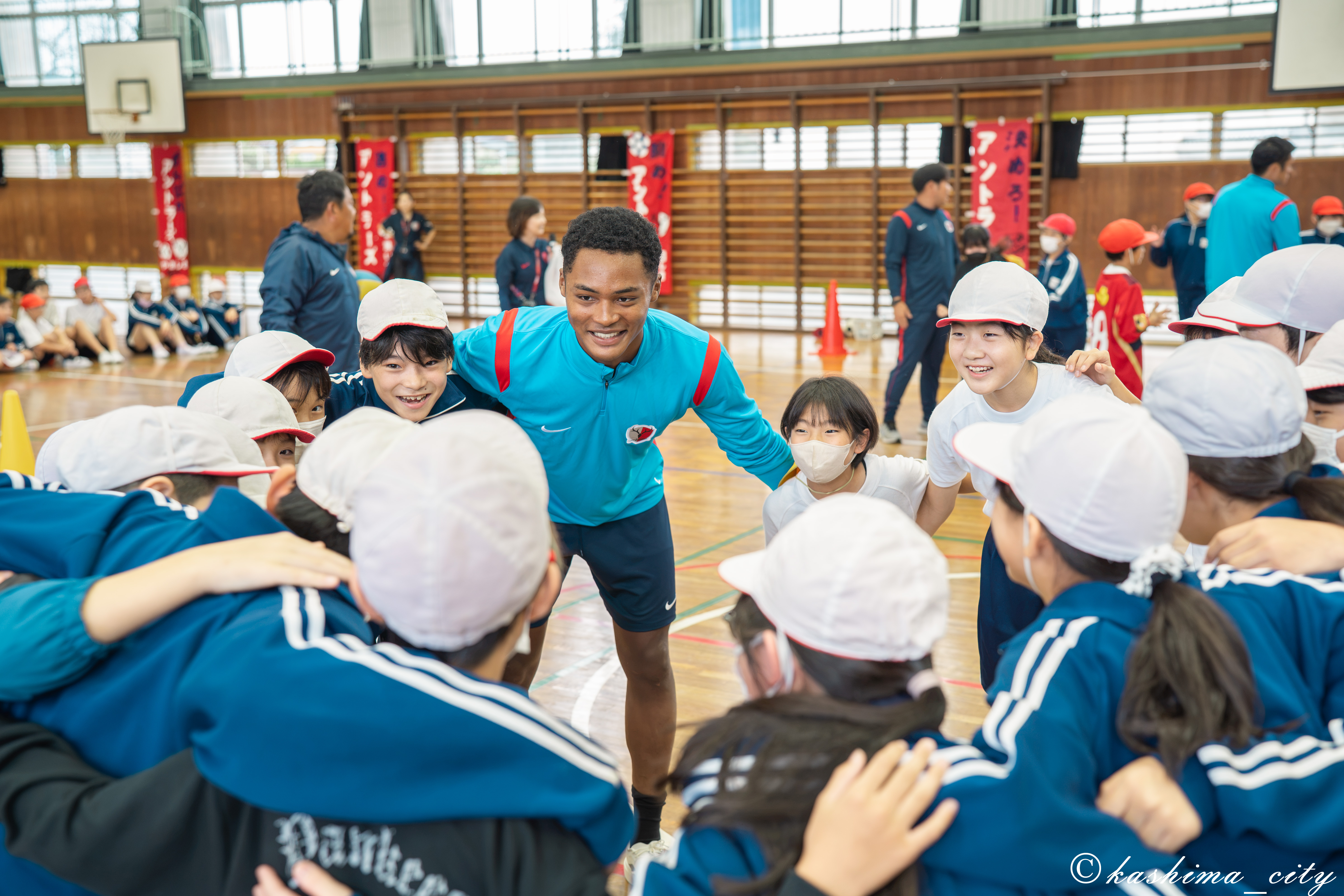 児童たちと円陣を組むウデンバ選手