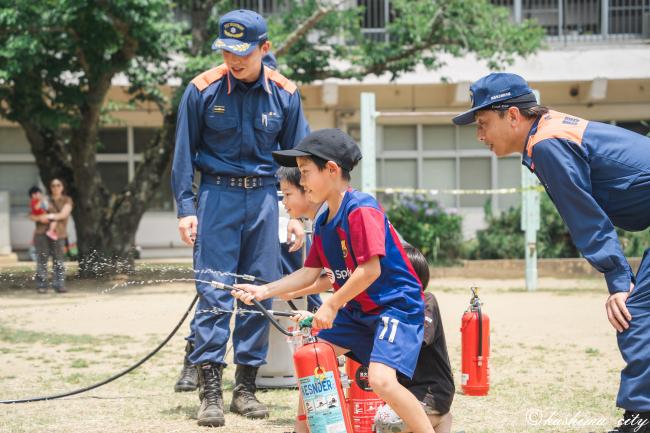 消火器の訓練をする少年たち